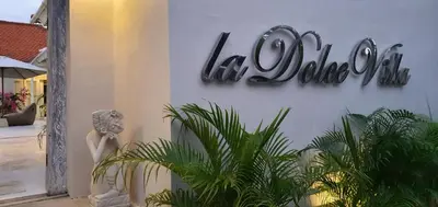 a sign on the side of a building with a statue at La Dolce Villa in Seminyak