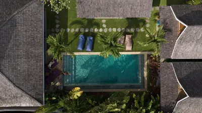an overhead view of a swimming pool with palm trees at Villa Du Bah - Cozy Tropical 3BR Villa 12min To Beach in Kerobokan