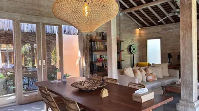 a living room with a table and a couch at Villa Du Bah - Cozy Tropical 3BR Villa 12min To Beach in Kerobokan