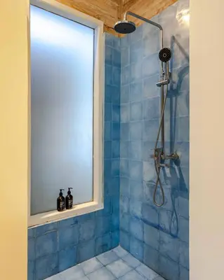 a blue tiled shower with a window in a bathroom at Villa Du Bah - Cozy Tropical 3BR Villa 12min To Beach in Kerobokan