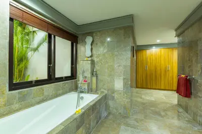 a bathroom with a bath tub and a window at Villa Kibbi in Seminyak