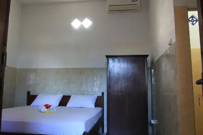 a small bedroom with a bed and a shower at Losmen Cempaka 3 in Kuta
