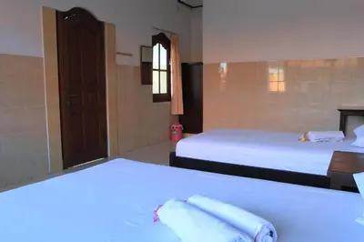 a hotel room with two beds with towels on them at Losmen Cempaka 3 in Kuta