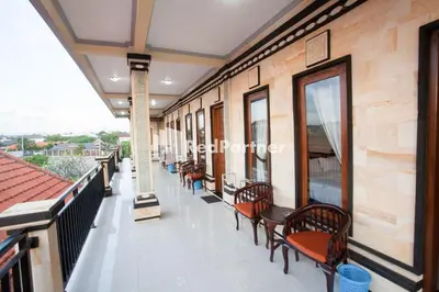 a balcony with benches and tables on a building at Wita Homestay Berawa in Canggu
