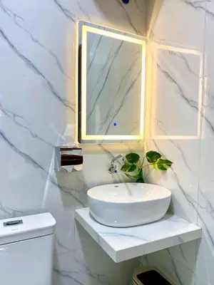 a white bathroom with a sink and a mirror at Wita Homestay Berawa in Canggu