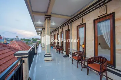 a balcony with chairs and tables on a building at Wita Homestay Berawa in Canggu