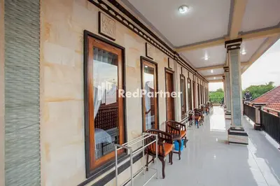 a balcony with chairs and windows on a building at Wita Homestay Berawa in Canggu