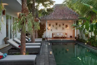 a villa with a swimming pool and palm trees at Room Sweet Room - Seminyak Center, walk to the Beach in Seminyak