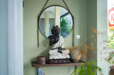 a mirror on a shelf next to a statue at Room Sweet Room - Seminyak Center, walk to the Beach in Seminyak