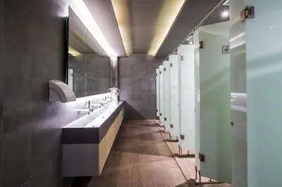 a bathroom with a sink and a row of mirrors at H-ostel Bali in Kuta
