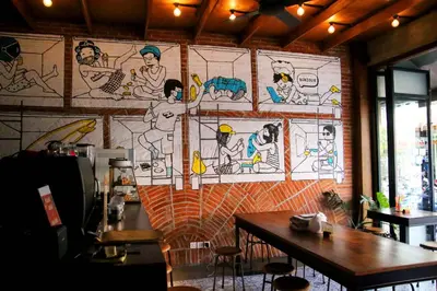 a wall in a restaurant with a mural on it at H-ostel Bali in Kuta