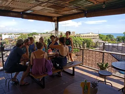 a group of people sitting at a table on a balcony at H-ostel Bali in Kuta