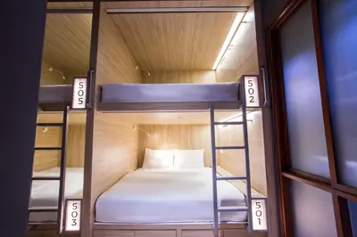 a room with two bunk beds in a house at H-ostel Bali in Kuta