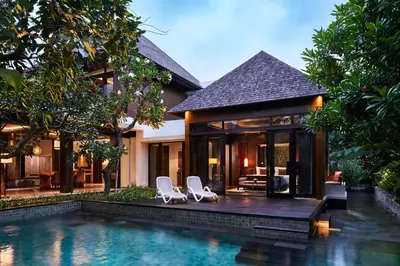 a house with a swimming pool in front of a house at The Anvaya Beach Resort Bali in Kuta