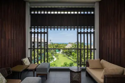 a living room with a large window and a couch at The Anvaya Beach Resort Bali in Kuta