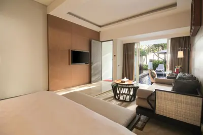 a hotel room with a bed and a living room at The Anvaya Beach Resort Bali in Kuta