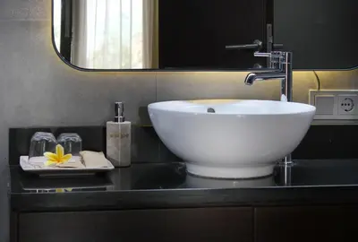 a bathroom with a white sink on a black counter at Sudha Villa Bali Baik-Baik in Seminyak