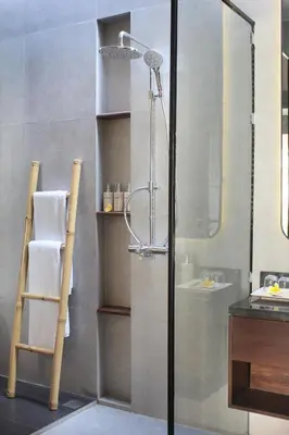 a bathroom with a shower and a glass door at Sudha Villa Bali Baik-Baik in Seminyak