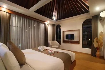a hotel room with a bed and a tv at Sudha Villa Bali Anyelir in Seminyak