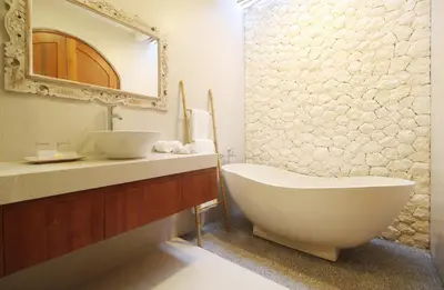 a bathroom with a white bath tub and a sink at Sudha Villa Bali Anyelir in Seminyak