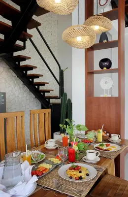 a dining room table with food on it at Sudha Villa Bali Anyelir in Seminyak