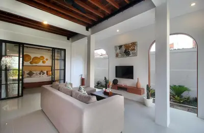 a living room with a couch and a tv at Sudha Villa Bali Anyelir in Seminyak