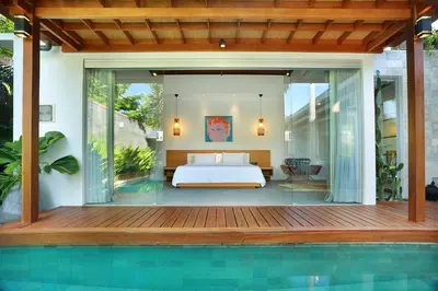 a bedroom in a villa with a bed and a pool at Villa Odyssey in Seminyak