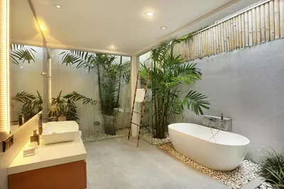 a bathroom with a large bath tub and a sink at Villa Odyssey in Seminyak