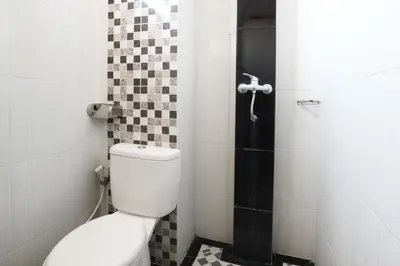 a bathroom with a toilet and a shower at Pondok 3 Mertha in Kuta