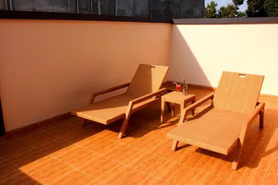 two chairs and a table on a porch at Pondok 3 Mertha in Kuta