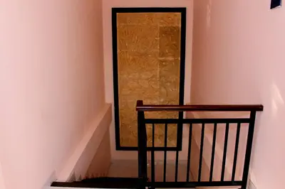 a stairway with a chair and a glass door at Pondok 3 Mertha in Kuta