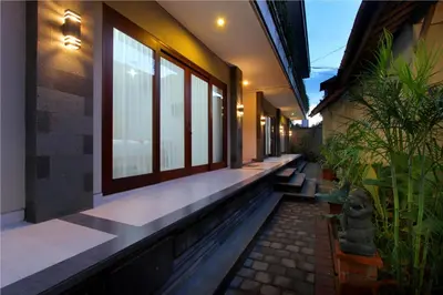 a hallway of a house with windows and plants at Sleepwell Seminyak in Seminyak