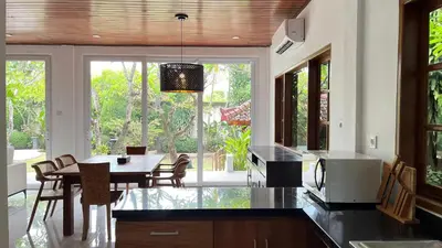 a kitchen with a table and chairs and a dining room at Baliana Villa Legian in Legian