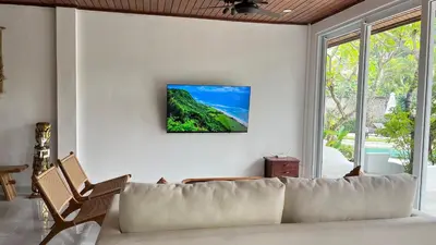 a living room with a white couch and a window at Baliana Villa Legian in Legian
