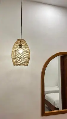 a pendant light hanging next to a mirror at Baliana Villa Legian in Legian