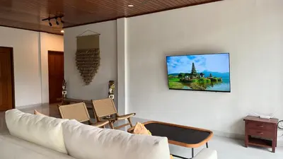 a living room with a white couch and chairs at Baliana Villa Legian in Legian