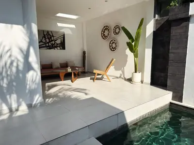a living room with a swimming pool and a couch at Aster Villa Seminyak in Seminyak