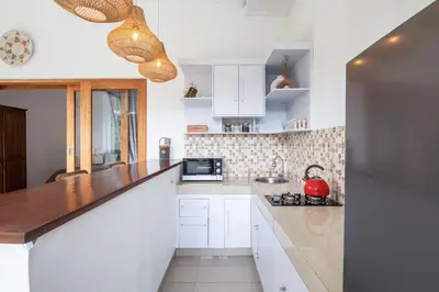 a kitchen with white cabinets and a counter top at Adorable 1BR villas in the heart of Seminyak in Seminyak