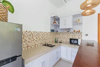 a kitchen with white cabinets and a refrigerator at Adorable 1BR villas in the heart of Seminyak in Seminyak
