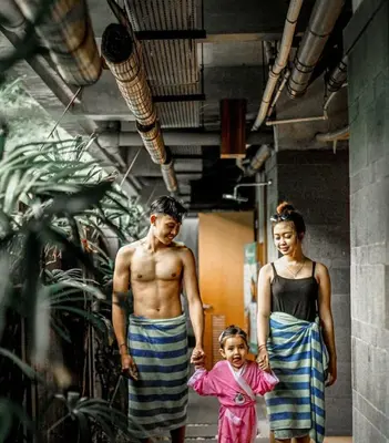 a man and a woman and a little girl holding hands at Swiss-Belexpress Kuta Legian in Kuta