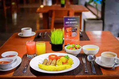 a table with a plate of food on a table at Swiss-Belexpress Kuta Legian in Kuta
