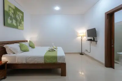 a bedroom with a bed with a television and a bathroom at Villa Sedana, Seminyak - 2 Bedroom Private Pool Villa! in Seminyak