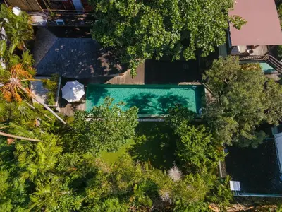 an overhead view of a swimming pool surrounded by trees at Jadine Bali Villa by Nagisa Bali in Canggu