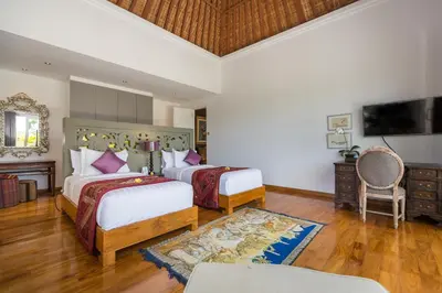 a hotel room with two beds and a tv at Jadine Bali Villa by Nagisa Bali in Canggu