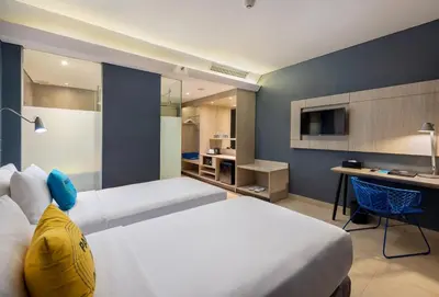 a hotel room with a large bed and a desk at Solia Legian Bali in Legian