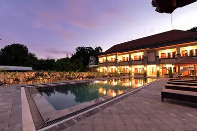 a resort with a swimming pool at night at Le Lima in Kuta