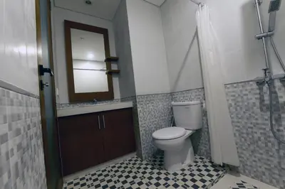 a bathroom with a toilet and a sink and a mirror at Le Lima in Kuta
