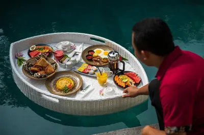 a man sitting on a boat with a tray of food at Villa Sally in Canggu