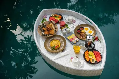 a table of food on a boat in the water at Villa Sally in Canggu
