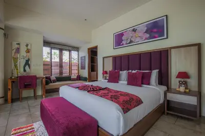 a bedroom with a large bed with a purple headboard at Villa Sally in Canggu